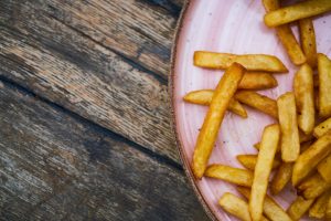 Hand-cut French fries in a paper container from an independent food stand