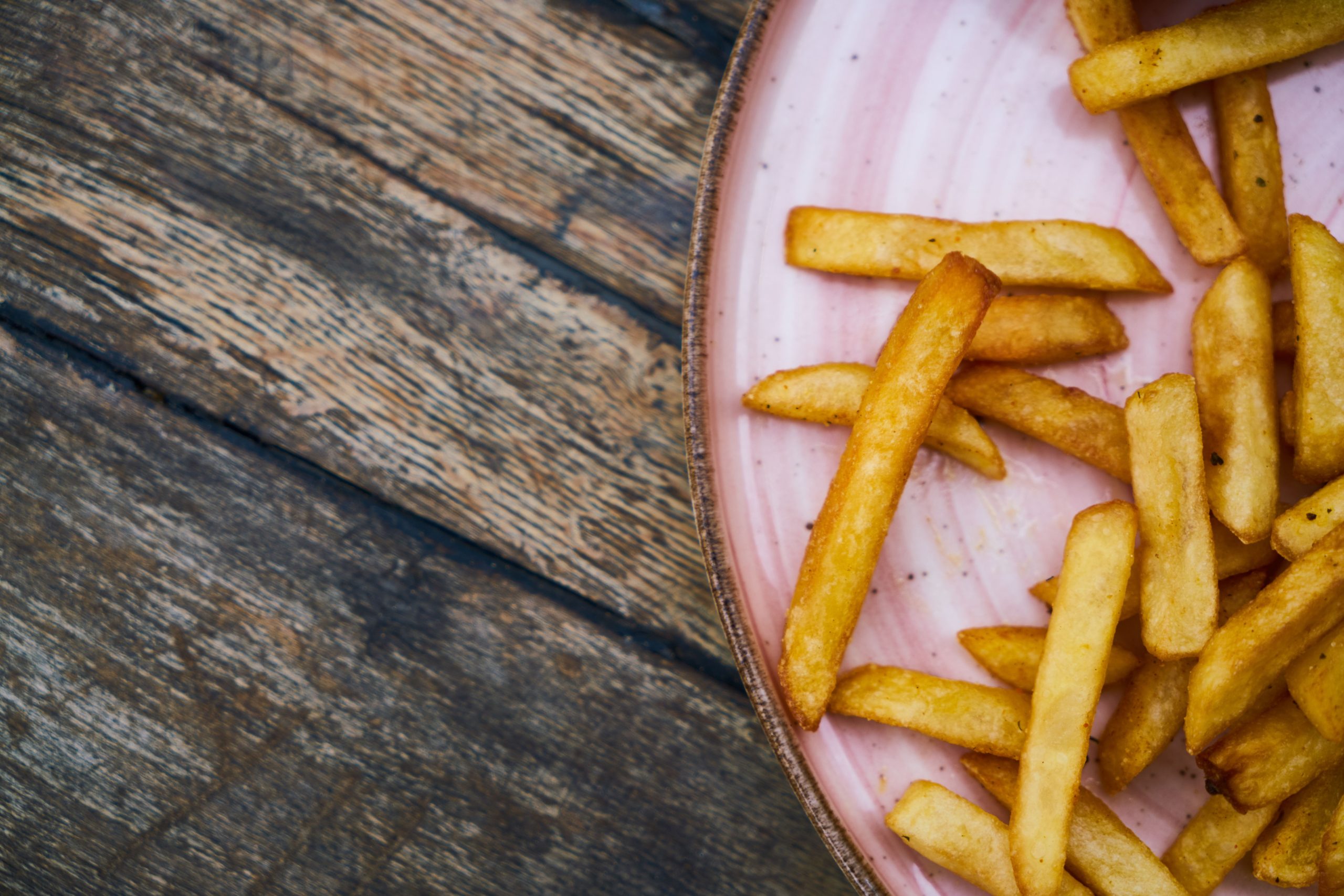 Hand-cut French fries in a paper container from an independent food stand